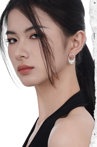 Close-up of S925 sterling silver earrings with irregular texture on female model's ear