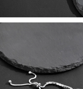 Close-up of adjustable silver tennis bracelet with cubic zirconia and slide buckle