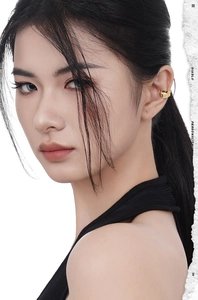 Close-up of minimalist gold ear cuff on female ear with smooth polished metallic finish
