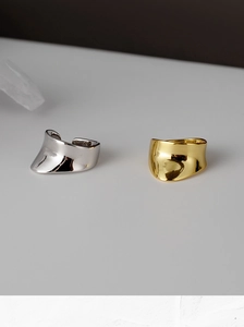 Macro detail of minimalist silver and gold wave rings with mirror polished surface