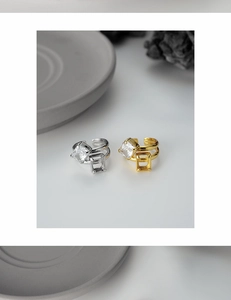 Macro view of double-layered geometric rings with square zircon stones in gold and silver