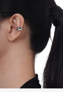 Macro shot of silver wave ear cuff with minimalist concave design and mirror finish