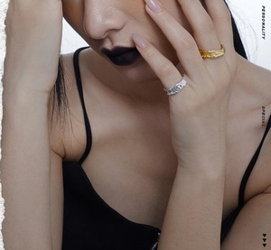 Close-up of gold and silver S925 rings with irregular texture on model's fingers