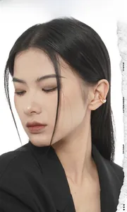 Détail d'un ear cuff doré irrégulier avec perle de nacre sur un style minimaliste