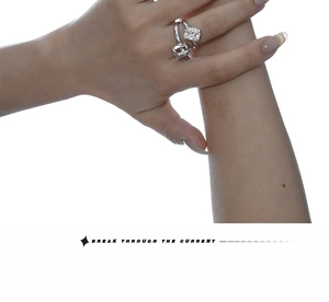 Macro detail of silver adjustable open ring featuring two sparkling square step-cut zircons