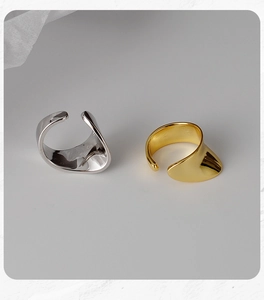 Detailed view of minimalist wave-shaped sterling silver clip earrings in gold and silver