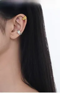 Detail view of gold hammered and silver textured ear cuffs on a female model