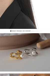 Détail de boucles d'oreilles géométriques irrégulières dorées et argentées avec perles