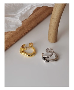 Close-up of gold and silver irregular double-layered ear cuffs with micro-pave crystals
