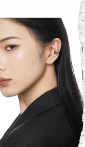 Macro detail of a minimalist silver ear cuff on ear with a polished mirror finish