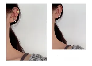 Detailed view of irregular silver ear cuffs with embedded crystals worn on the ear bone