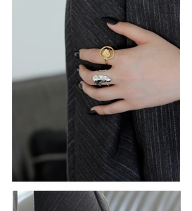 Detail of silver lava texture and gold hollow rings on model hands with suit