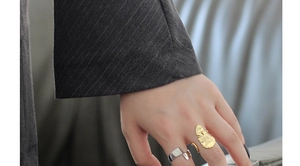 Detail showing irregular gold lava texture and silver geometric rings on a model hand