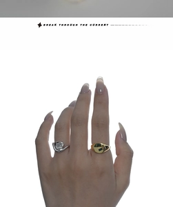 Detail of silver irregular twist ring and gold signet ring with black stone inlay