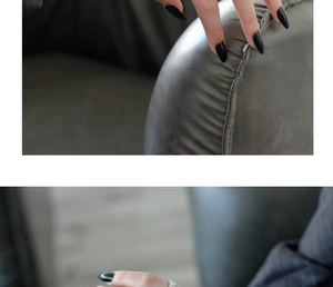 Close-up of matte black long stiletto press-on nails with irregular silver ring detail