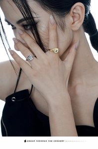 Close-up of minimalist silver irregular ring and gold ring with square green gemstone