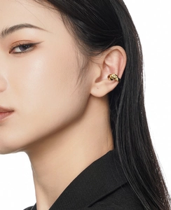 Close-up of minimalist gold knot ear cuff on ear cartilage without piercing