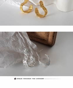 Detail of S925 silver earrings with irregular lava texture in gold and silver finish
