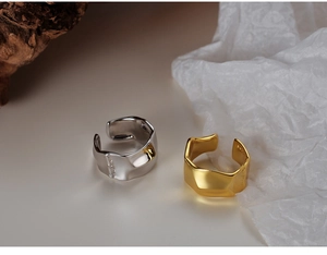 Detail showing irregular molten texture and S925 hallmark on silver and gold wide rings