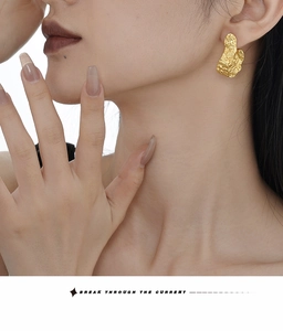 Close-up of S925 sterling silver earring with wrinkled lava texture in gold finish