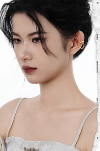 Close-up of a minimalist gold-plated double hoop ear cuff on model's ear without piercing