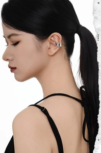 Macro shot of silver ear cuff with pleated texture on model's ear, sleek minimalist style