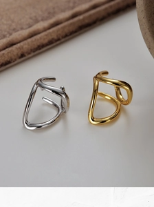 Detail view of gold and silver minimalist wavy hollow lines rings with polished finish