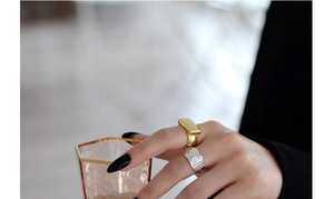 Detail of minimalist gold rectangle signet and silver hammered textured rings on hand
