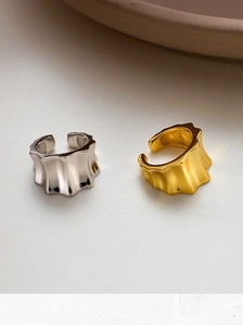 Detailed close-up of wavy S925 sterling silver ear cuffs in gold and silver mirror finish