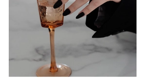 Close-up of matte black almond-shaped press-on nails on a high-end marble surface