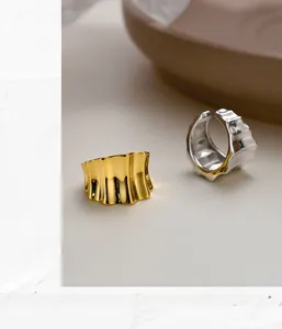 Macro detail of gold and silver S925 sterling silver ear cuffs with liquid metal ripples