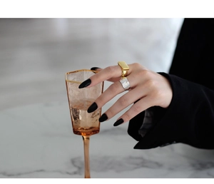 Detail of silver textured irregular ring and gold geometric band on model finger