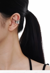 Close-up of a silver pleated ear cuff with high-shine metallic finish on a model