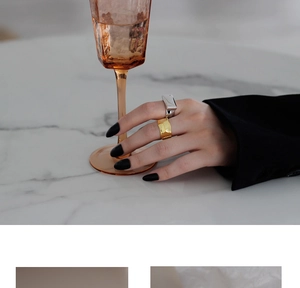 Close-up of minimalist gold wave and silver geometric rings on a stylish hand