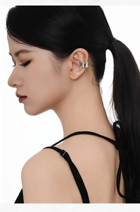 Close-up of a silver wavy textured ear cuff worn on the cartilage without piercing