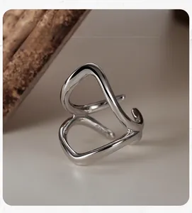 Detail view of a polished S925 sterling silver ear cuff with minimalist wavy hollow lines