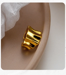 Macro shot of minimalist gold lava textured ring with high-gloss mirror finish design