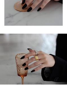 Detail of irregular textured gold band and silver signet ring on model's hand