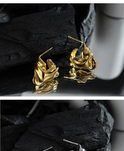 Macro detail of irregular lava texture earrings in gold and silver finish with mirror effect