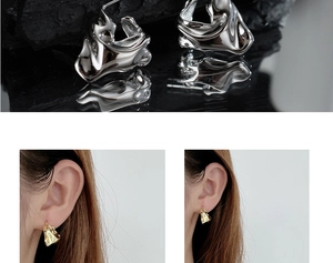 Detailed close-up of irregular silver and gold molten lava texture earrings