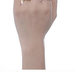 Detailed view of the wavy textured 925 silver ring in gold on a model's finger
