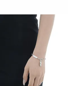 Detail of silver S925 bracelet with baroque pearl and hammered texture metal pendant