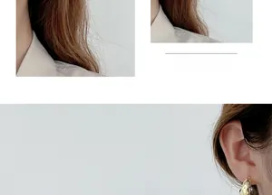 Close-up of golden irregular foil texture hoop earrings with minimalist metal design