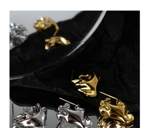 Artistic display of irregular lava texture earrings in polished gold and silver finishes