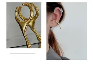 Macro detail of golden liquid metal ear cuff showing irregular drop design and model fitting