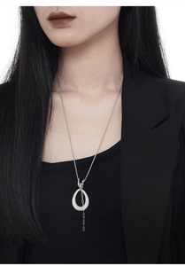 Détail du pendentif asymétrique en argent avec cristaux pavés sur une longue chaîne texturée
