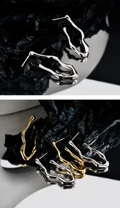 Macro view of S925 sterling silver stamp on minimalist irregular wavy drop earrings