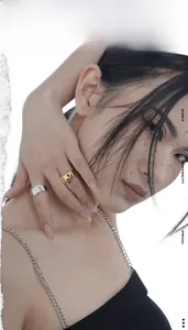 Artistic close-up of gold and silver irregular textured rings on a model hand