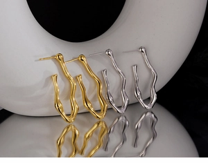 Detailed view of wavy S925 sterling silver C-shaped earrings in gold and silver finish