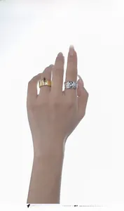 Detail of a gold ring with red gemstone and a silver irregular textured lava ring